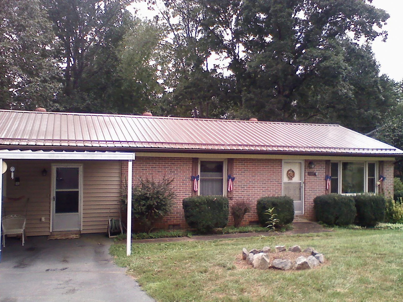 Bronze metal roof and carport on a brick ranch home — Roof Repair work by our crew in Caledonia